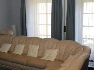 a white leather couch in a living room with windows at Ferienwohnung Marquis in Bad Sobernheim