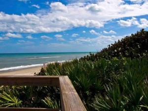 a view of the beach from a wooden boardwalk at Hidden Gem Hideaway Homely in West Melbourne