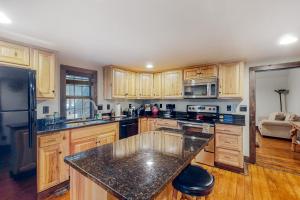 a kitchen with wooden cabinets and a black counter top at War Eagle Homestead Cabin in Rambo Riviera