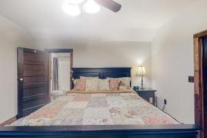 a bedroom with a large bed with a large bedspread at War Eagle Homestead Cabin in Rambo Riviera