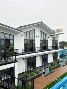 Cẩm Xuyên的住宿－HOMESTAY THIÊN CÂM，一座白色的大建筑,前面设有一个游泳池