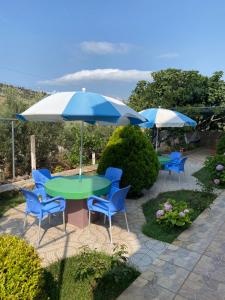 una mesa y sillas con sombrillas en el patio en Villa Tani Ksamil, en Ksamil