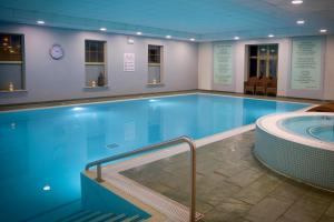 une grande piscine avec un bain à remous dans l'établissement Cambridge Belfry Hotel & Spa, à Cambridge