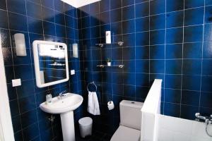 a blue tiled bathroom with a sink and a toilet at Nomad Villa Santa Fe in Las Palmas de Gran Canaria