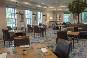 a restaurant with tables and chairs and windows at Cambridge Belfry Hotel & Spa in Cambridge