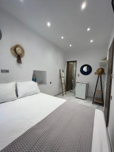 a bedroom with a white bed and a hat on the wall at reAdy studio in Skiathos
