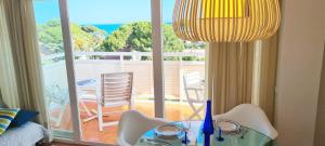Habitación con mesa y vistas a un balcón. en Miramar Serveis - Vistas Increíbles a la Bahía Terraza y Parking, en Cambrils
