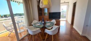 een eetkamer met een glazen tafel en witte stoelen bij Miramar Serveis - Vistas Increíbles a la Bahía Terraza y Parking in Cambrils