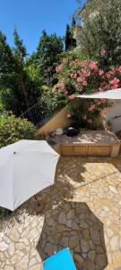 um guarda-chuva branco sentado em cima de um pátio de pedra em Casa Panorama Lovran - Sea View Apartment NEW! em Lovran