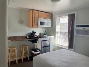 a small room with a bed and a kitchen at Moontide Motel, Apartments, and Cabins in Old Orchard Beach