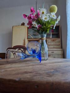 un jarrón de flores sentado sobre una mesa en Dreamcatcher & Retro Hostel, en Žužemberk