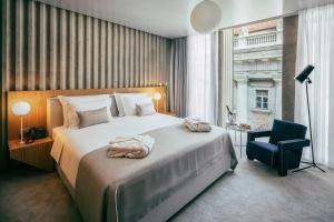 a bedroom with a large bed and a blue chair at Met Boutique Hotel in Zagreb