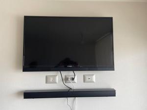 einen Flachbild-TV, der an einer Wand hängt in der Unterkunft Excelente departamento nuevo a pasos de la playa in La Serena