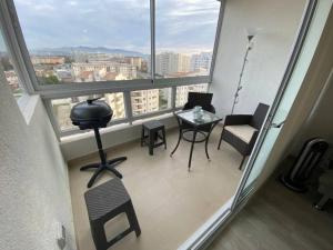 einen Balkon mit einem Tisch und Stühlen in einem Zimmer mit Fenstern in der Unterkunft Excelente departamento nuevo a pasos de la playa in La Serena