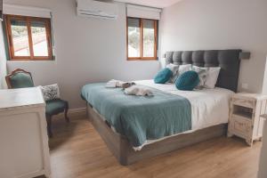 a bedroom with a bed with a dog laying on it at Casa dos Avós - Folgosa Douro in Folgosa