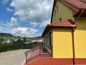 a yellow building with a balcony on a street at TOTEM in Skhidnitsa