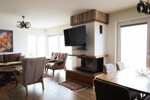 Villa Ozoni - Jezerc في فيريزاي: غرفة معيشة فيها تلفزيون وطاولة وكراسي