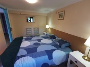 1 dormitorio con 1 cama azul y blanca con 2 sillas en Casa São Pedro Belinho ONLY PILGRIMS, en Belinho