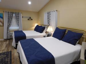 2 Betten in einem Hotelzimmer mit blauen Kissen in der Unterkunft Rainbow Courts in Rockdale