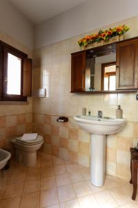 La salle de bains est pourvue d'un lavabo, de toilettes et d'un miroir. dans l'établissement La Terrazza Apartment - Smart Holiday, à Mantoue