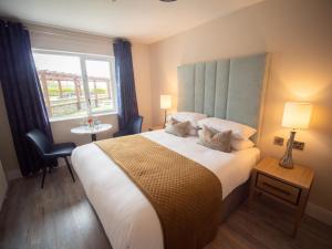 a bedroom with a large bed and a window at Ocean Sands Hotel in Enniscrone