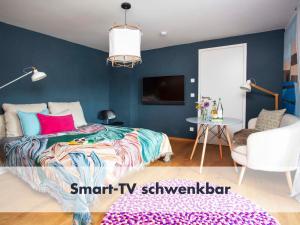 1 dormitorio con paredes azules, 1 cama y 1 silla en Bio, Natur, Zirbe, Seenähe, Bergblick Bleibe am Berg II en Schliersee