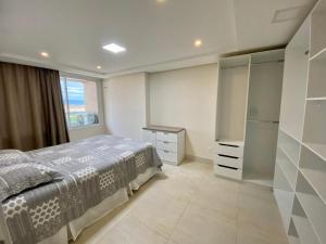 a bedroom with a bed and a dresser and a refrigerator at Apartamento confortável, localização extra -recepção 24h- Varanda com vista panorâmica in Juazeiro do Norte +11 photos