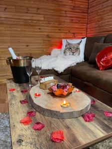 un chat assis sur un canapé à côté d'une table dans l'établissement Romantique chalet avec sauna et jacuzzi extérieur, à Arthon