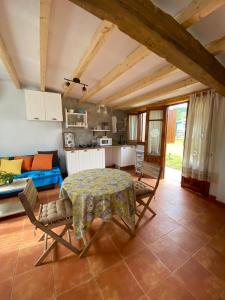 Una cocina y una sala de estar con mesa y sillas. en casamarietacantabria, en Reocín