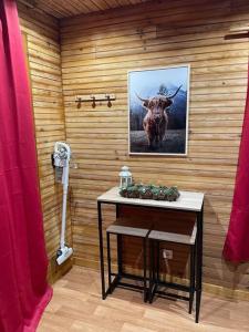 a room with a table with a picture of a bull at Romantique chalet avec sauna et jacuzzi extérieur in Arthon