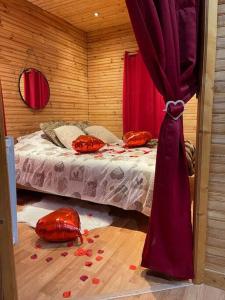 a bedroom with a bed with red hearts on the floor at Romantique chalet avec sauna et jacuzzi extérieur in Arthon