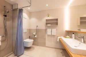 ein Bad mit einem Waschbecken, einem WC und einer Dusche in der Unterkunft Seehörnle Bio Hotel & Gasthaus in Gaienhofen
