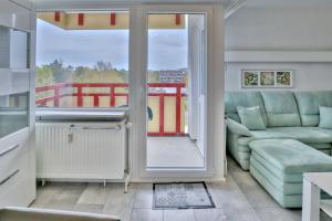 een woonkamer met een bank, een tafel en een raam bij Terrassenhaus, FeWo 66 in Duhnen