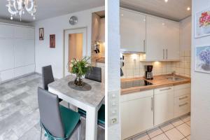 een keuken met witte kasten en een tafel met stoelen bij Terrassenhaus, FeWo 66 in Duhnen