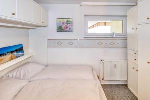 een slaapkamer met twee bedden en een raam bij Terrassenhaus, FeWo 66 in Duhnen +13 foto's