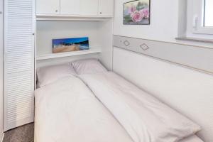 een kleine slaapkamer met een bed in de hoek bij Terrassenhaus, FeWo 66 in Duhnen