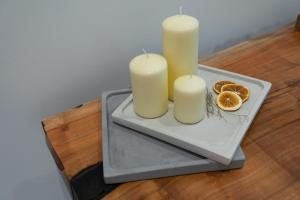 two candles on a tray with oranges on a table at ANASSA studios in Parga
