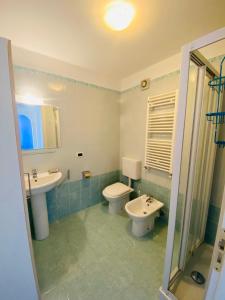 a bathroom with a toilet and a sink and a mirror at Costa Azzurra Aparment in Grado