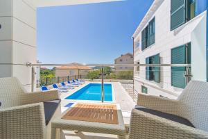 a balcony with chairs and a swimming pool at Apartments Casa Blanca y Verde in Slano