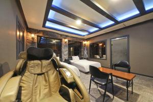 um quarto com uma cama, uma mesa e cadeiras em Carlton Hotel em Incheon