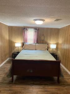 een slaapkamer met een groot bed met 2 lampen bij WandaBrooks Place in Pine Bluff