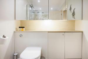 een badkamer met witte kasten en een toilet bij Hyde Park Hideaway Sleeps 6 in Londen