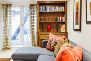 een woonkamer met een bank en een boekenplank bij Hyde Park Hideaway Sleeps 6 in Londen