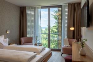 a hotel room with two beds and a large window at Seehörnle Bio Hotel & Gasthaus in Gaienhofen