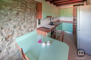 eine Küche mit Tisch und Kühlschrank in der Unterkunft Namastè Apartment Città Alta with hills view in Bergamo