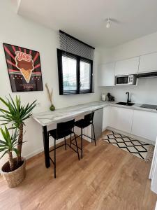 cocina con mesa y sillas en una habitación en Studio Isana - avec piscine, en Ambarès-et-Lagrave