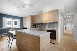 a kitchen with wooden cabinets and a dining room at Modern - Work friendly - Quiet area in Bergen