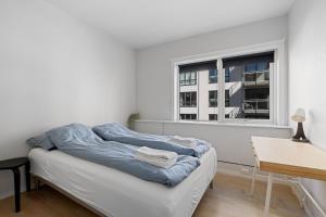 a white room with a bed and a window at Modern - Work friendly - Quiet area in Bergen
