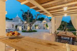 een tafel met een fruitschaal op een patio bij Trulli Ericla Resort in Castellana Grotte