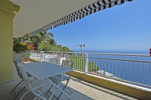 un tavolo e sedie su un balcone con vista sull'oceano di CASA MARGHERITA a Ospedaletti